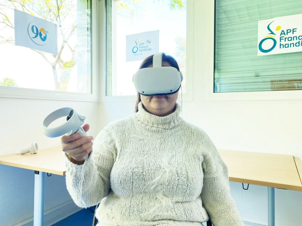 Photo d'une personne qui utilise un casque de réalité virtuelle lors d'une sensibilisation dans les locaux APF France handicap 44